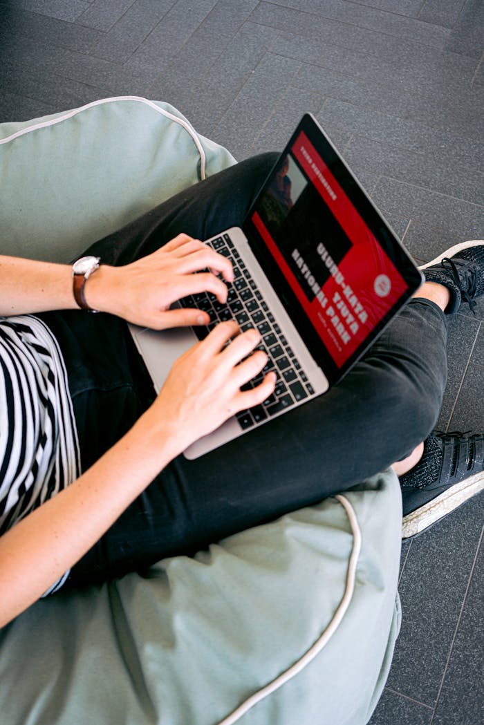 home-img Person working remotely on a laptop while sitting comfortably on a beanbag chair indoors.